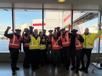 a group of people in safety vests standing in a room