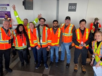 a group of people wearing orange vests and posing for a photo