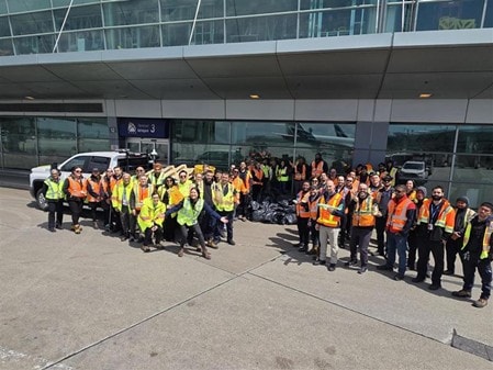 a group of people in yellow vests standing outside a building
