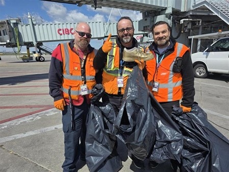 a group of men in safety vests holding a fish