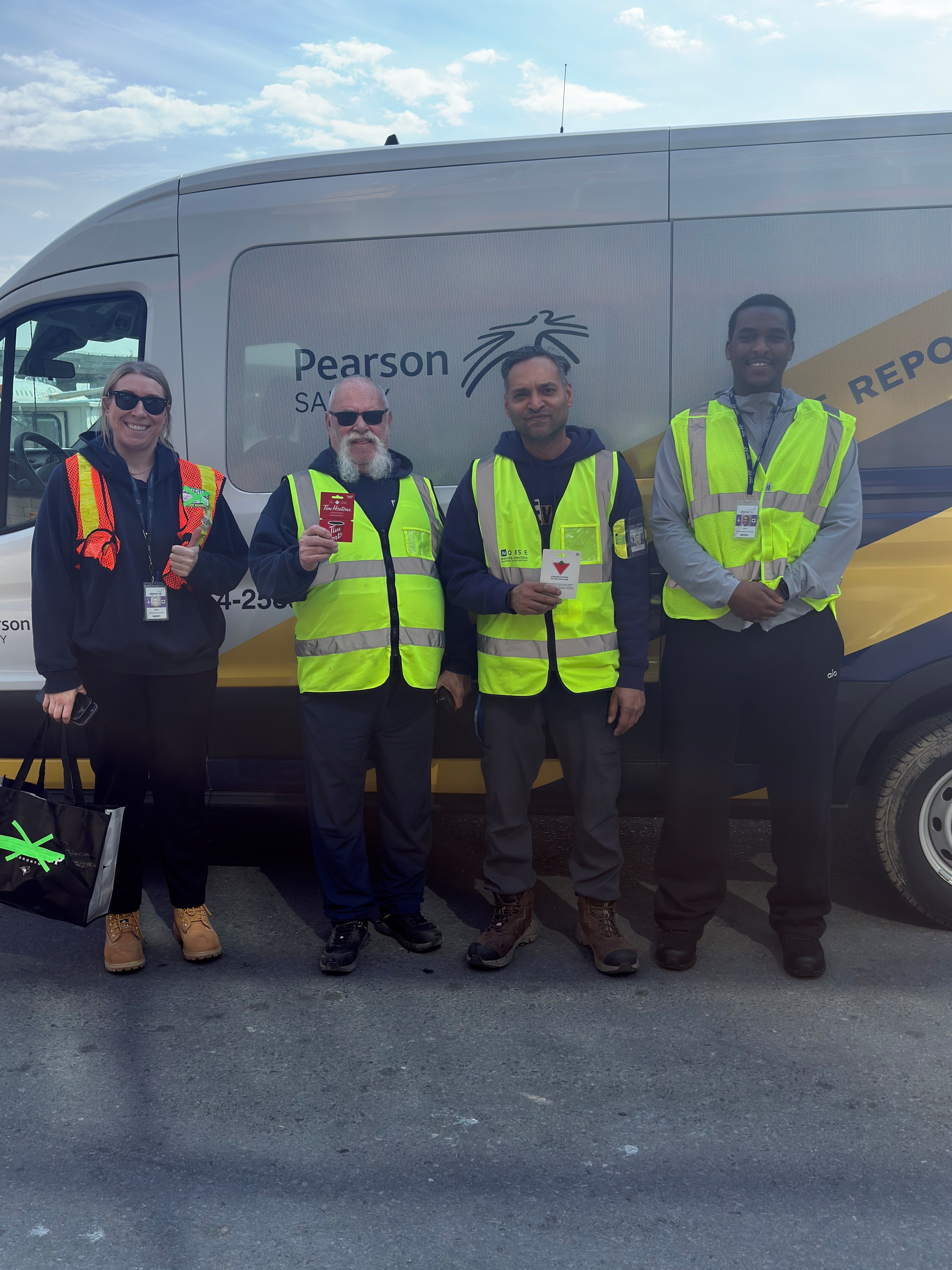 a group of men in safety vests standing in front of a truck