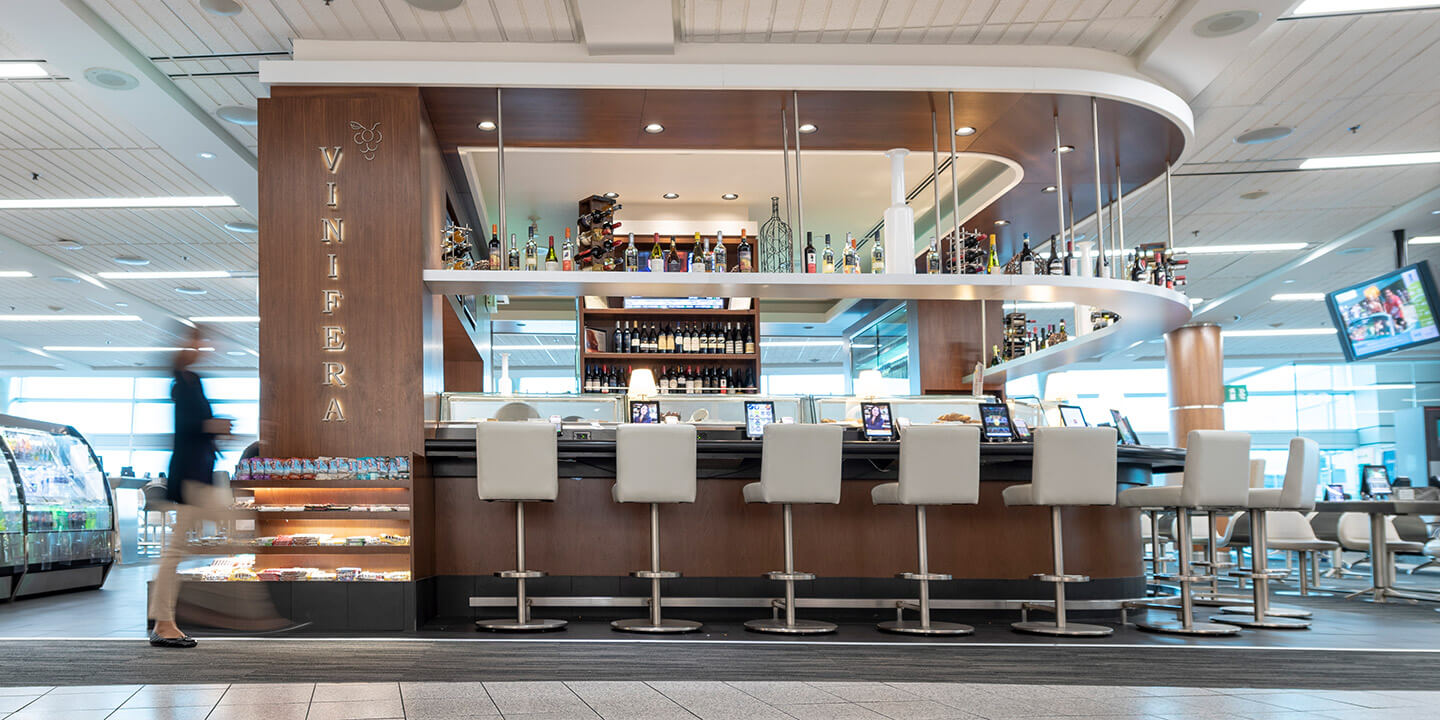 Vinifera wood-lined bar with white raised chairs 