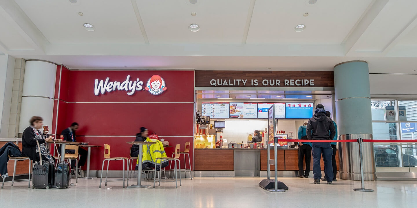 Wendy's sign on a red wall with seating area and serving counter