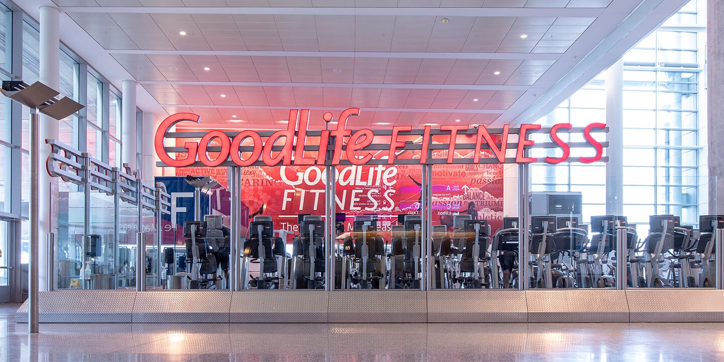 Goodlife Fitness sign above row of exercise equipment.