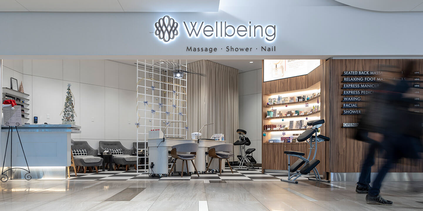 Devanture de Wellbeing Spa avec des sièges de massage, un comptoir et des étalages de produits. 