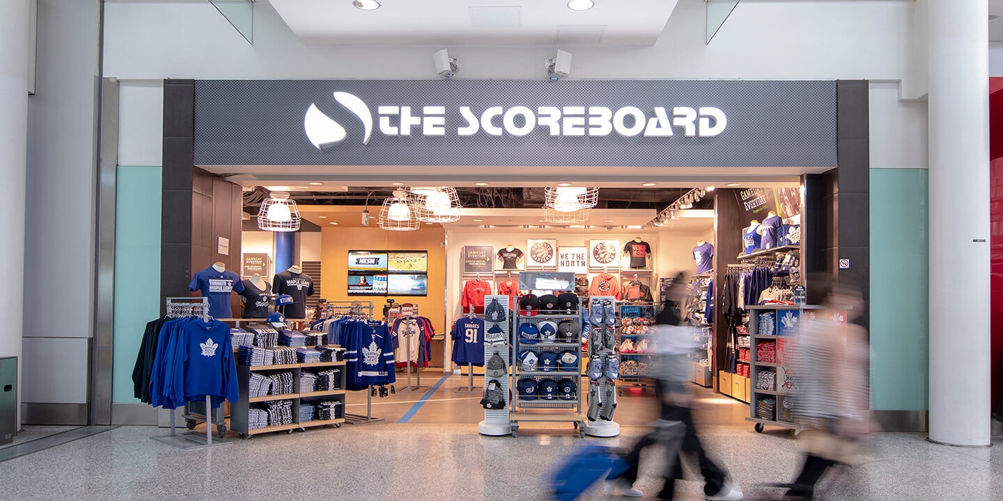 Vue extérieure du magasin The Scoreboard avec des vêtements et des marchandises en exposition.
