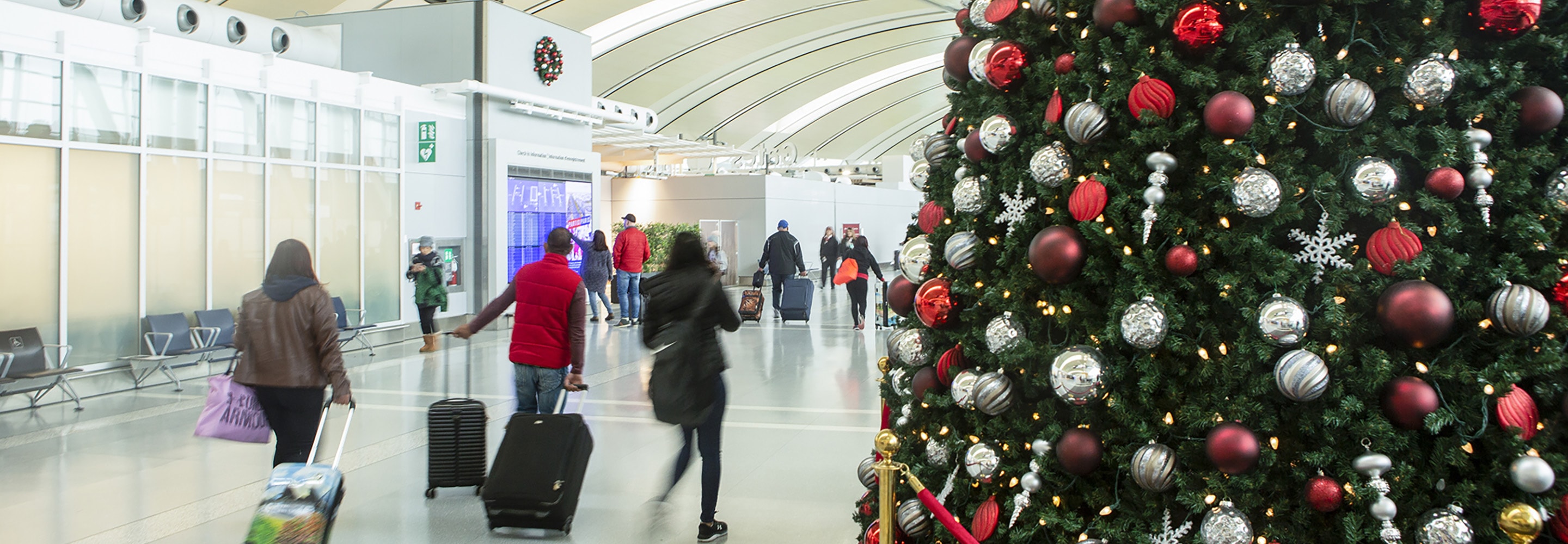 arbre de noël et passagers marchant avec des bagages dans le terminal