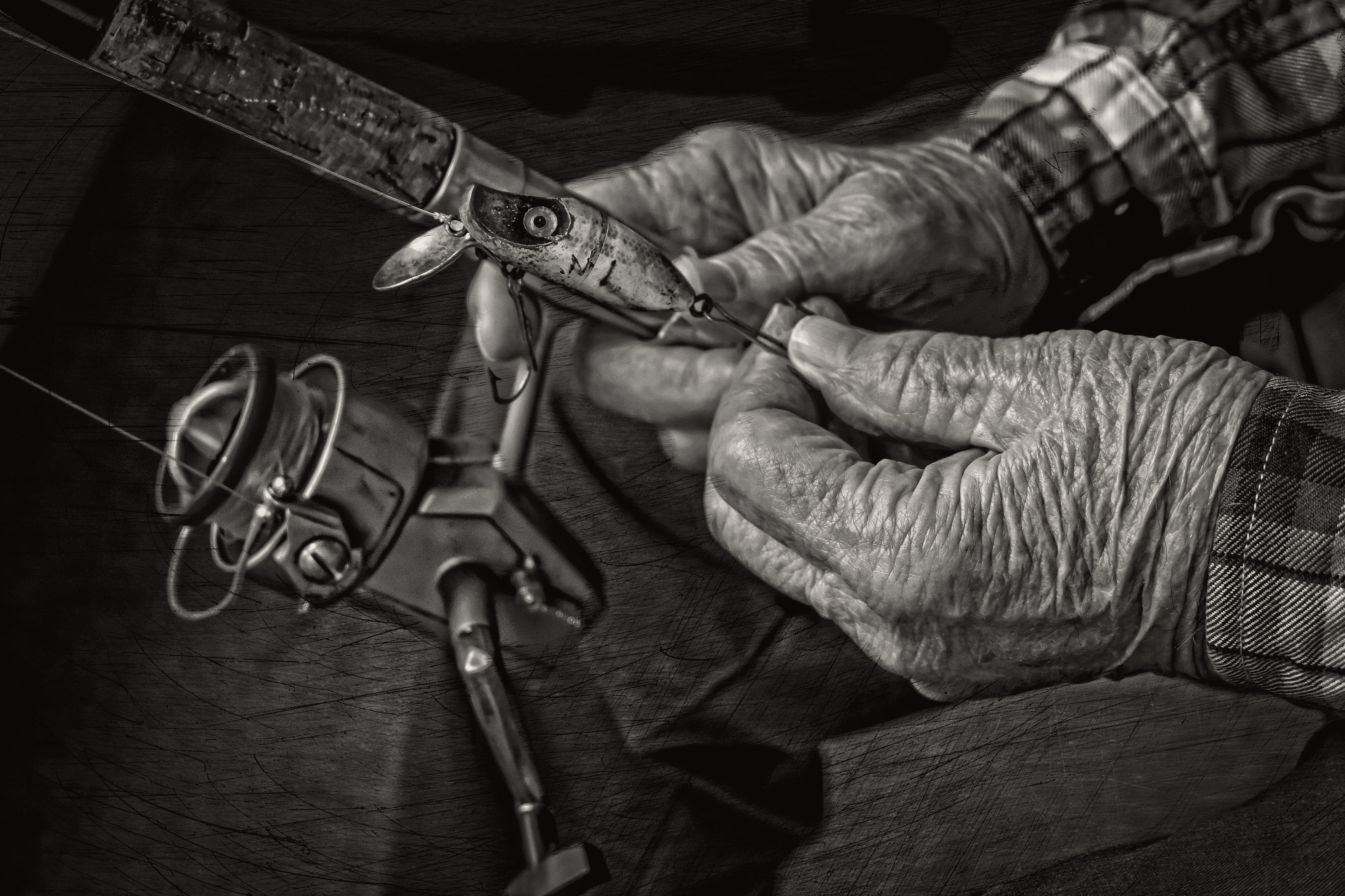 Elderly hands holding a fishing rod