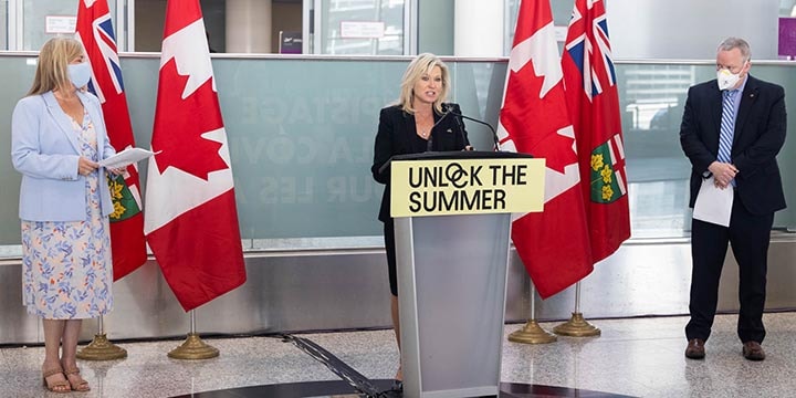Mississauga Tourism CEO Victoria Clarke, Mississauga Mayor Bonnie Crombie and Mississauga Board of Trade President and CEO Trevor McPherson at podium in Terminal 1 arrivals at Pearson airport